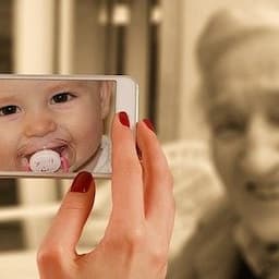 Un femme prend en photo, avec son smartphone, une personne agé mais sur l'écran du téléphone on voit un bébé